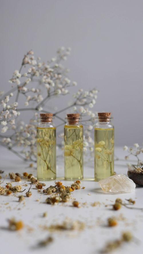 Amber apothecary vials and cold-pressed botanical oils on a dark surface